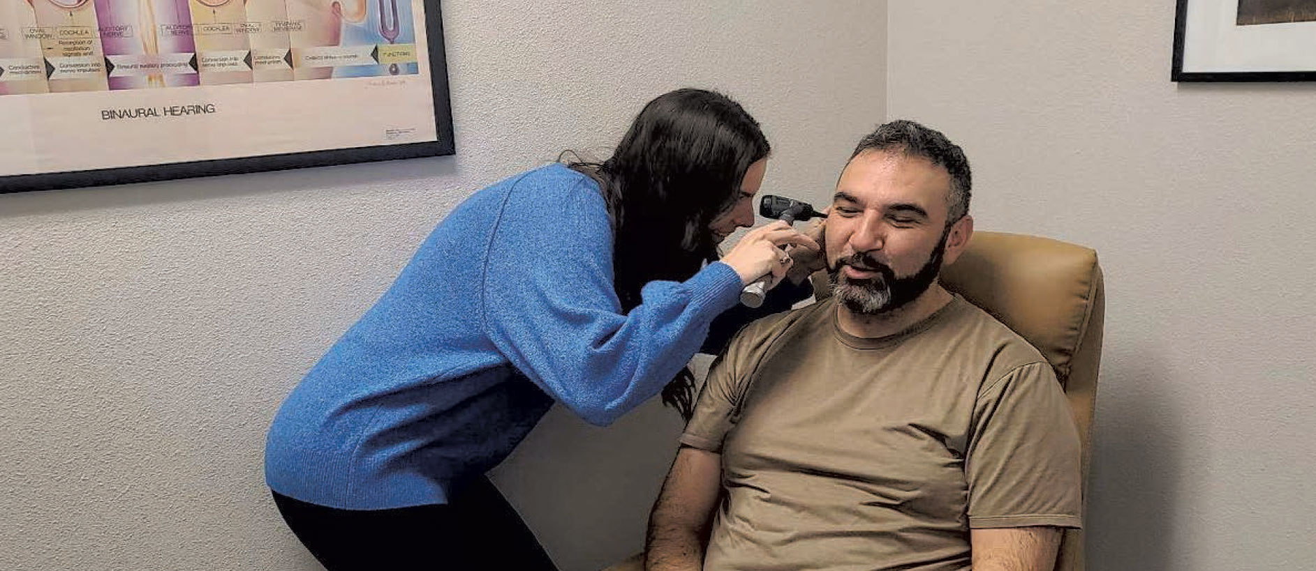 an audiologist inspecting a patient's ear