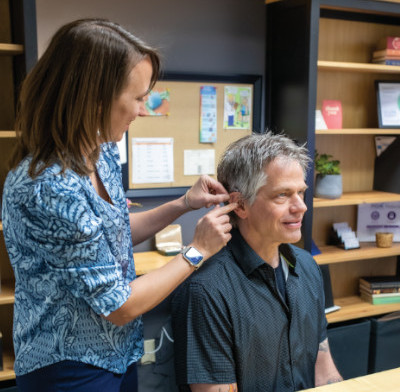 Chelsea of Family Hearing inserting a hearing device