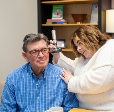 Chelsea of Family Hearing inserting a hearing device